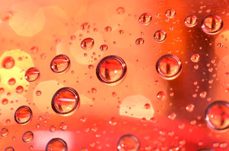 shiny clear water point attached to a glass reflects the same color as the color on the glass into a...
