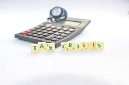 writing tax crisis from a green horrible block  with white backgraound and black calculator の写真素材