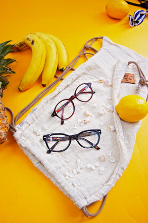 Fashion still life with sunglasses, fruits and shell on yellow backgroundの写真素材