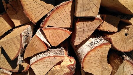 Chipped firewood is on the heap. Woodpile of firewood close-up. A stack of dry firewood, visible...