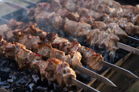 Pork shish kebab is cooked on the grill. Smoke from coalsの写真素材