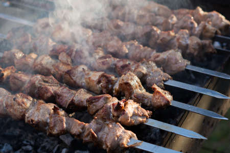 Pork shish kebab is cooked on the grill. Smoke from coalsの写真素材