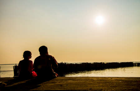 Two kids sit on the beachの写真素材