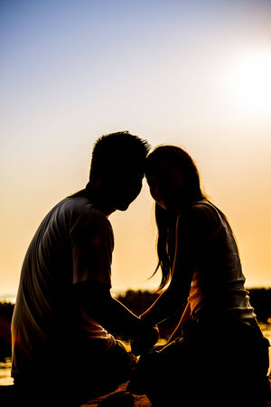 Lovely Couple sit in the sunset with silhouette sceneの写真素材