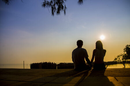 Lovely Couple sit in the sunset with silhouette scene3の写真素材