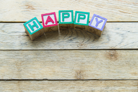 Wooden block word is HAPPY on wooden backgroundの写真素材