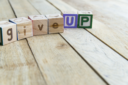 Wooden blocks are Give up word on wooden floorの写真素材