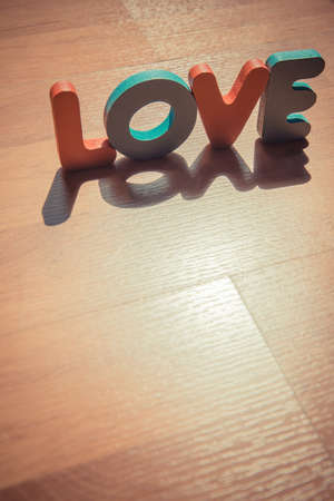 Wooden word LOVE on laminate floor in shadow shade styleの写真素材