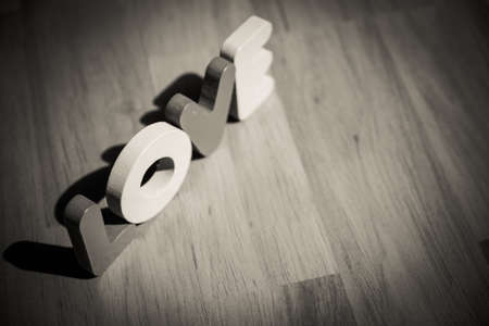 Wooden word LOVE on laminate floor in mono chrome styleの写真素材
