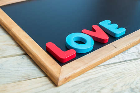 Wooden word LOVE on the corner of Black boardの写真素材