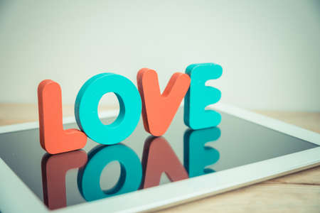 Wooden word LOVE stand on tablet in vintage styleの写真素材