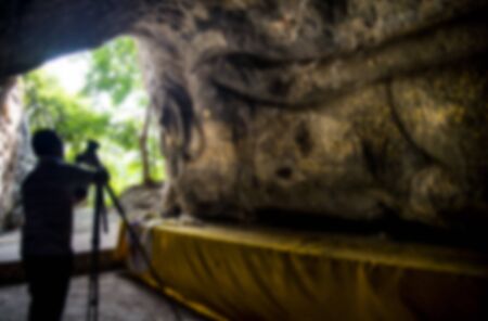 Buddha molding art on stone wall in Thai style with photographer in Blur styleの写真素材