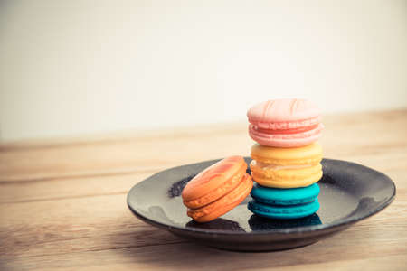 Colorful macaron in black dish on wooden floorin Vintage themeの写真素材