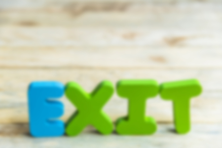 Colorful wooden word Exit on wooden floor in Blur style