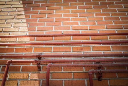 Piping on brown block wall