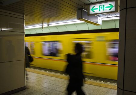 Blured people in underground subway in Japan with under exposure style