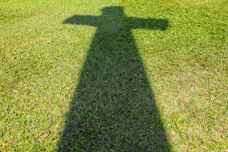 Shadow of Christian cross on green grass floorの写真素材