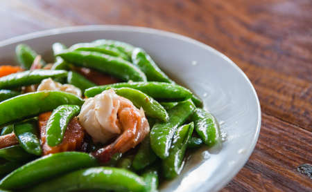 Shrimp stir and fried and green peas on white plate with selective focusの写真素材