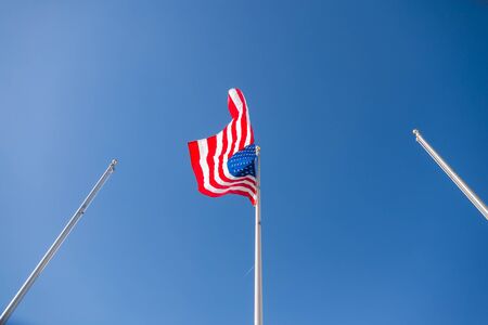 United States of America Flag on column with blue skyの写真素材