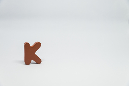 Brown Wooden alphabet K with white backgroundの写真素材