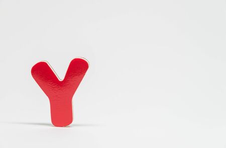 Red wooden alphabet Y with white background and selective focus
