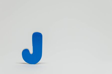 Blue wooden alphabet J with white background and selective focusの写真素材