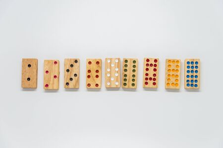 Sequence of wooden dominoes on white background with selective focusの写真素材