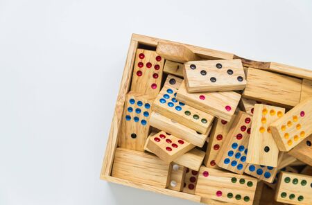 Wooden dominoes in wooden box on white background with selective focus