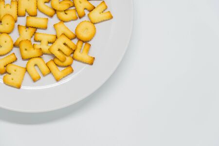 Alphabet cracker in dish with white backgroundの写真素材
