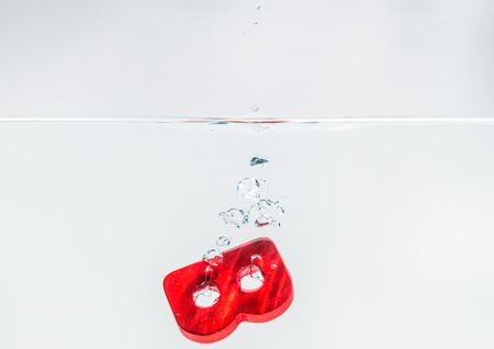 Red wooden alphabet B drop in the water with white background and selective focusの写真素材