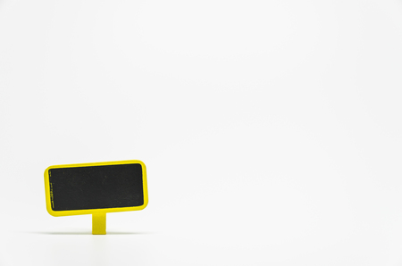 Yellow wooden black board with clip on white background and selective focusの写真素材