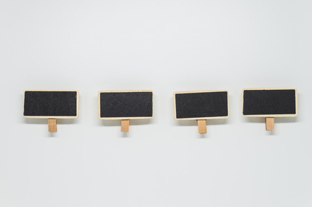Small wooden black board clip on white background with selective focusの写真素材