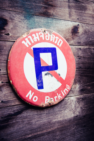 Rusty steel no parking sign in Thai language attached on classic wooden wallの写真素材