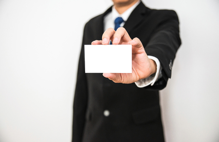Business man hold white name card paper on hand with isolated white backgroundの写真素材