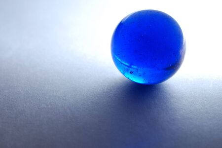 Backlit blue marble on white paperの写真素材
