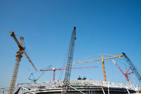 tower cranes on a background of blue skyの写真素材