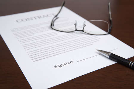 The concept with a contract, glasses, and pen on the desk.の写真素材