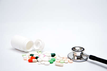 Pills and white bottle on white background.  With copy space in background. Used for health or medical manufacturing industry concept.の写真素材
