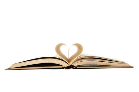 close up of opened book with heart shaped from two pages, isolated on white backgroundの写真素材