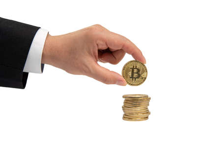Businessman's hand holds a gold coin bitcoin coin. Isolated on white backgroundの写真素材