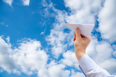 Businessman hand holding paper plane on sky Background.の写真素材