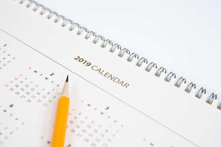 Desk calendar and yellow pencil on white background.の写真素材