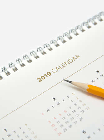 Desk calendar and yellow pencil on white background.の写真素材