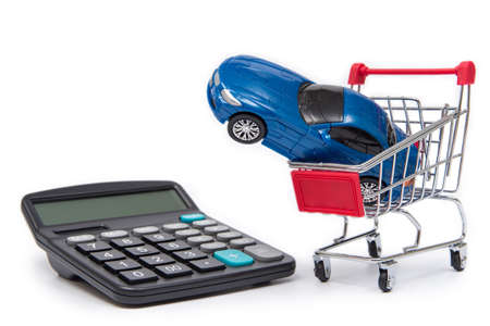 Mini shopping carts and calculators with toy cars on white background.の写真素材