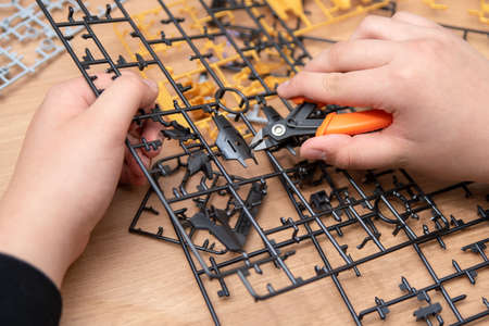 A boys hand assembling plastic models using tools.の写真素材