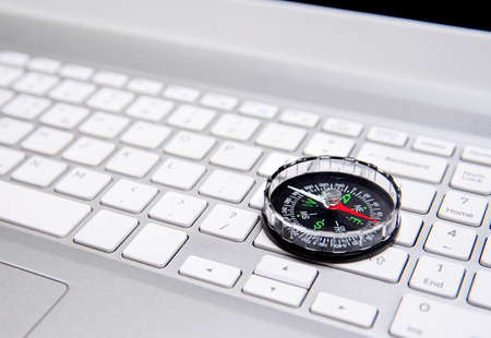Laptop keyboard and compass, internet navigation concept.の写真素材