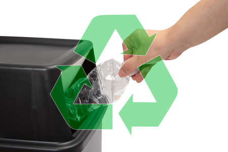 The hand of a man who throws a plastic bottle into a trash can.の写真素材