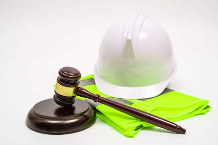 A labor-related legal concept with safety hats, work clothes, and a judge gavel on a white background.の写真素材