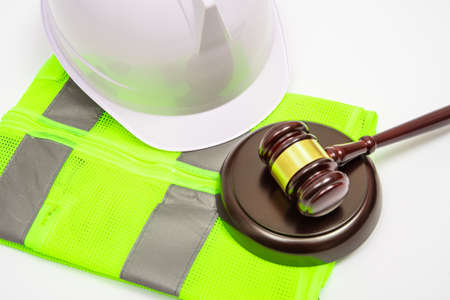 A labor-related legal concept with safety hats, work clothes, and a judge gavel on a white background.の写真素材