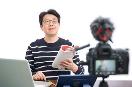 Online learning concept. An Asian middle-aged male teacher preparing to learn online.の写真素材